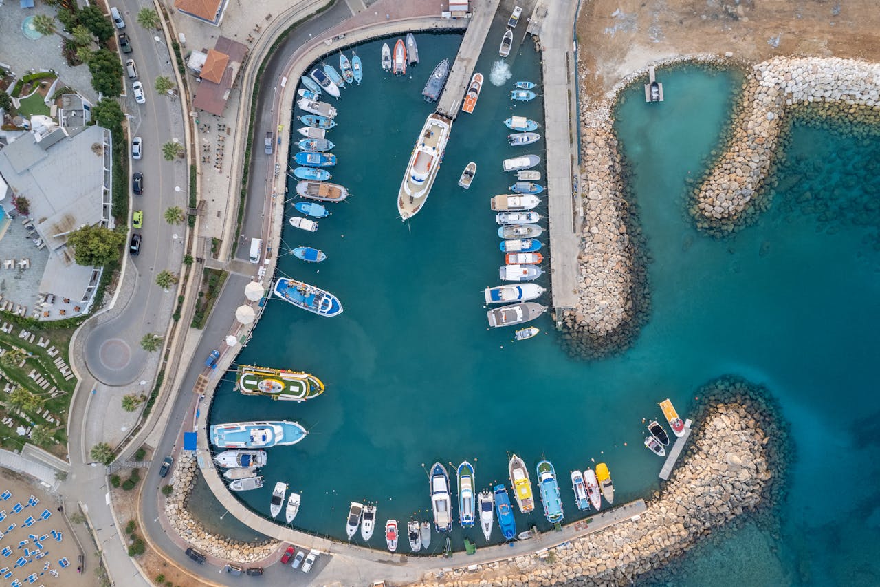 A stunning aerial view of a marina in Pernera, Famagusta, Cyprus showing boats docked in turquoise waters.