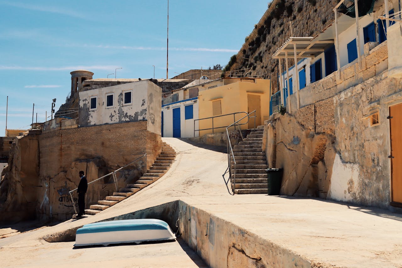 services-03 Explore the rustic architecture and coastal charm of Valletta's seaside steps on a sunny day.